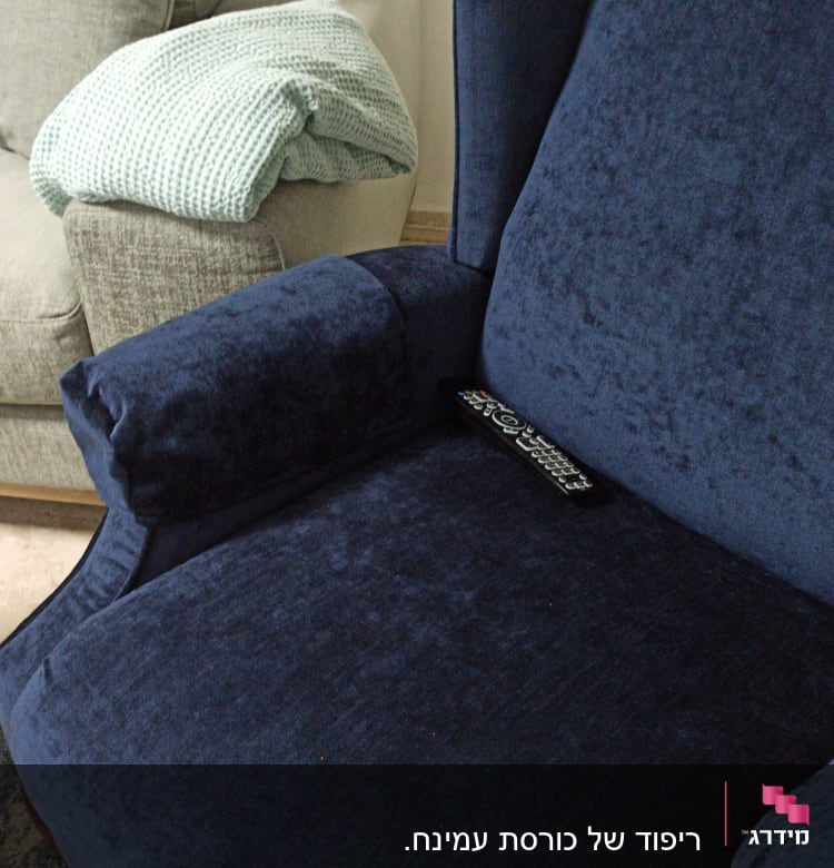 כורסה מרופדת בכחול עם שלט רחוק